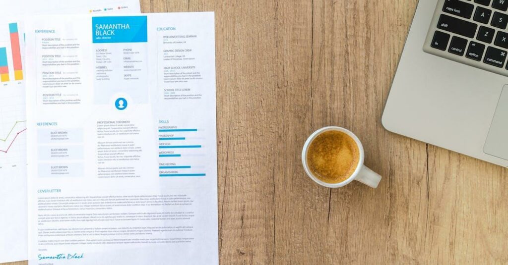 Top view of a desk with resume, coffee cup, and laptop on a wooden surface, ideal for business concepts.